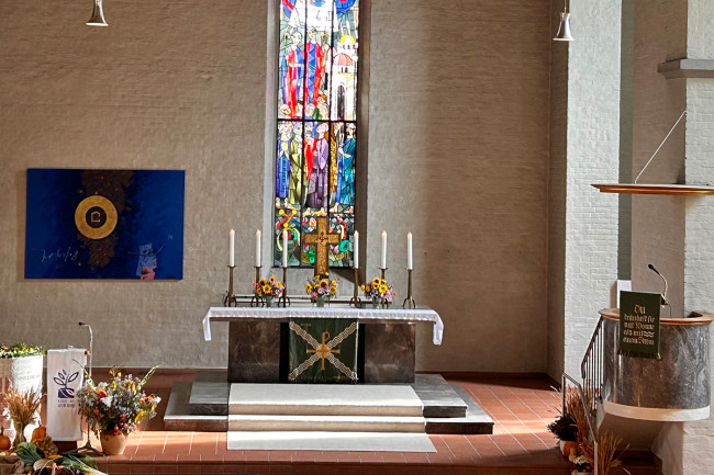 Der Altar mit Kreuz und Kerzen, geschmückt mit Erntedankblumen